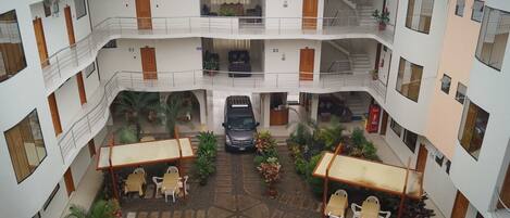 A multi-level atrium with a central courtyard, balconies, and a staircase.