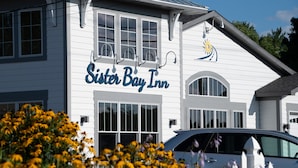 A white building with a sign reading "Sister Bay Inn." - Sister Bay Inn (Sister Bay)