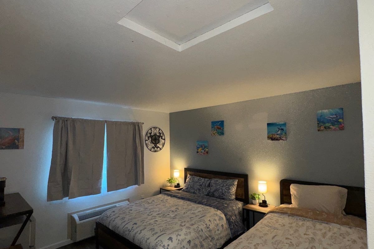 Een slaapkamer met twee bedden, dakraam, verwarming en bureau.