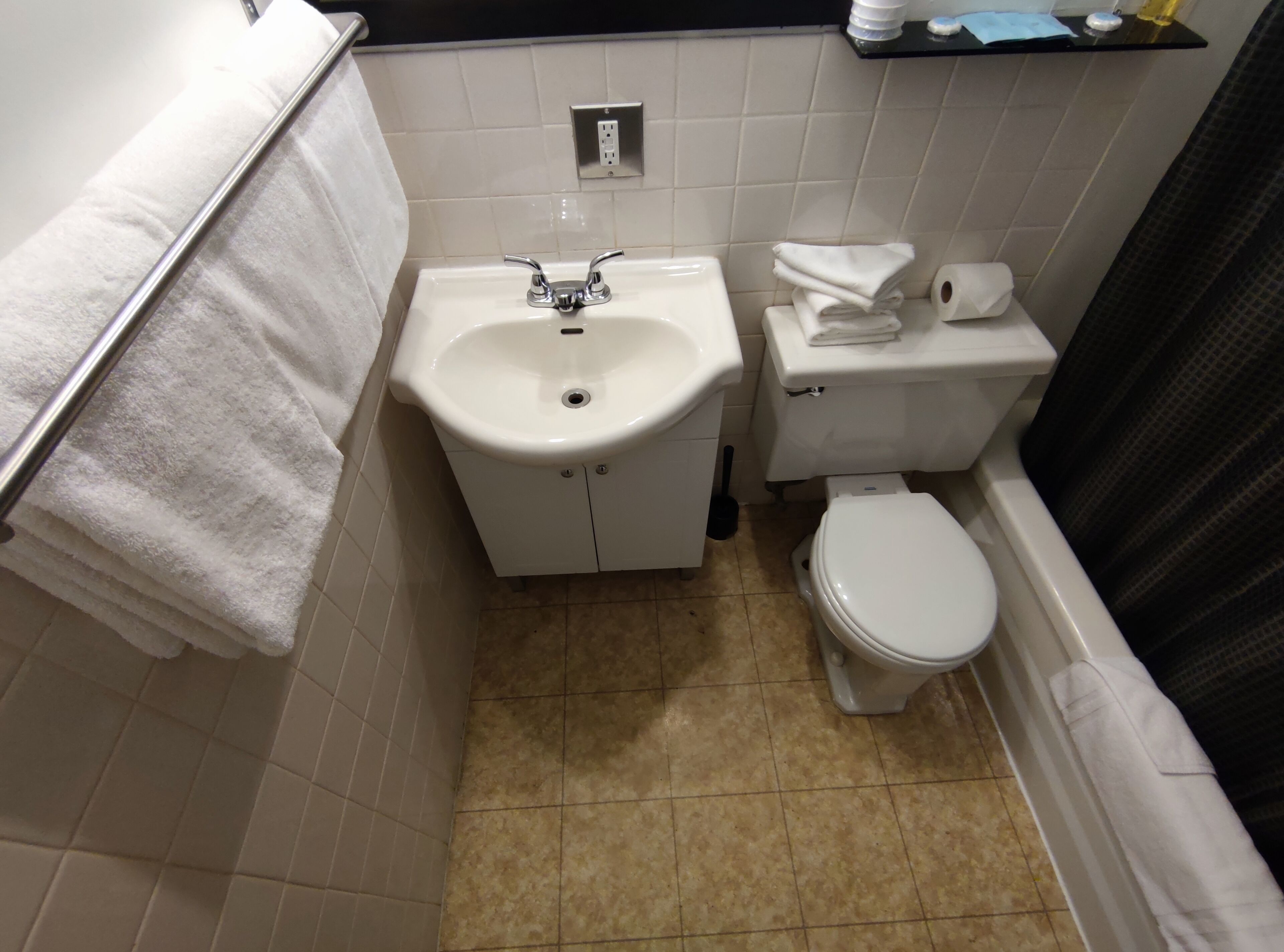 A small bathroom with a sink, toilet, and a shower curtain.