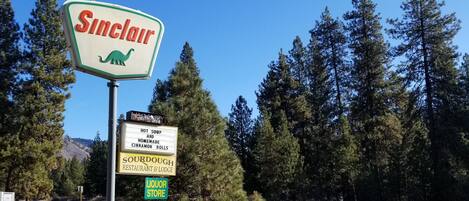 A sign for Sinclair with a dinosaur logo, indicating a restaurant and lodge.