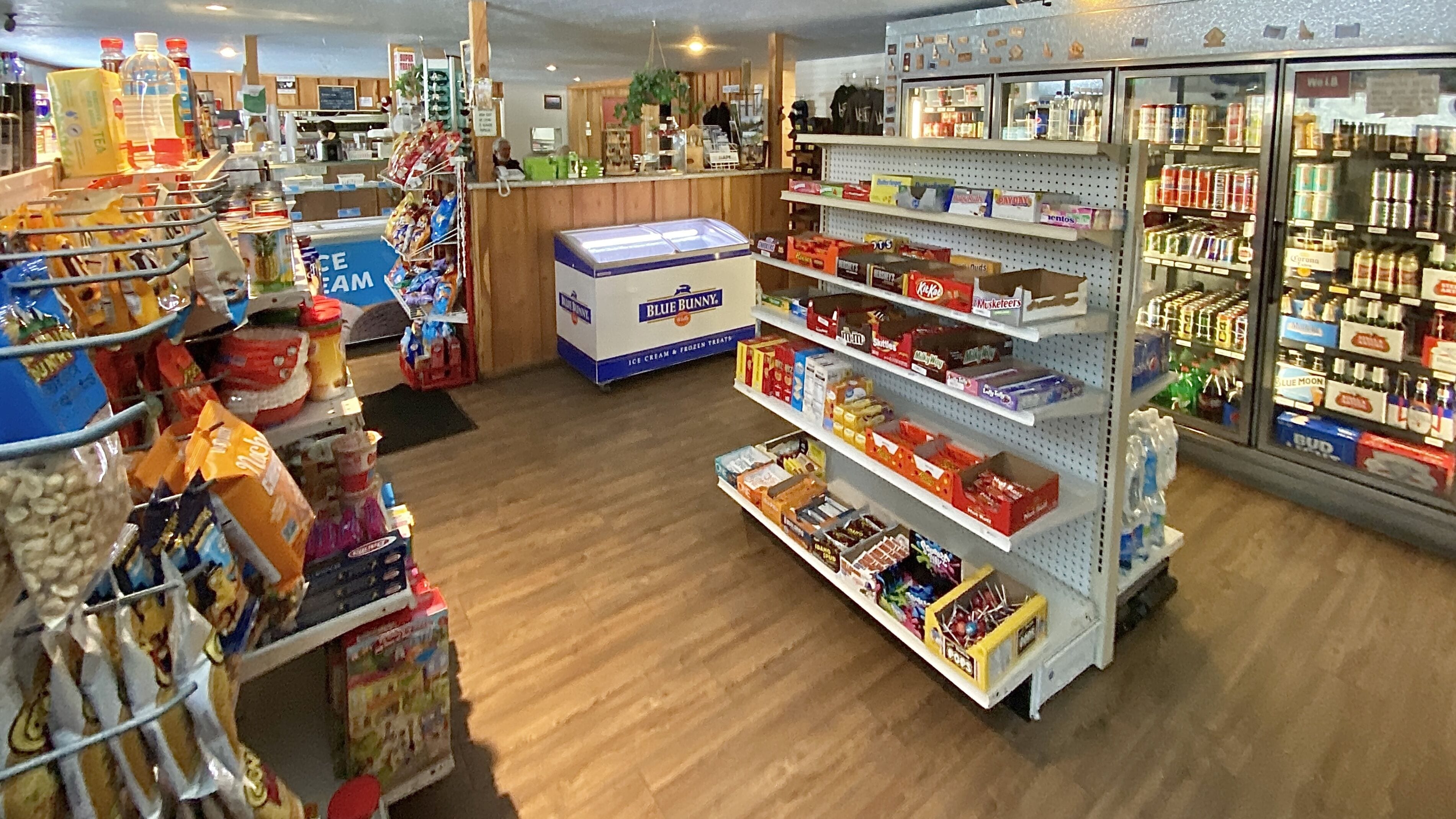 Ein Laden mit Regalen voller Snacks, Getränke und Eis.