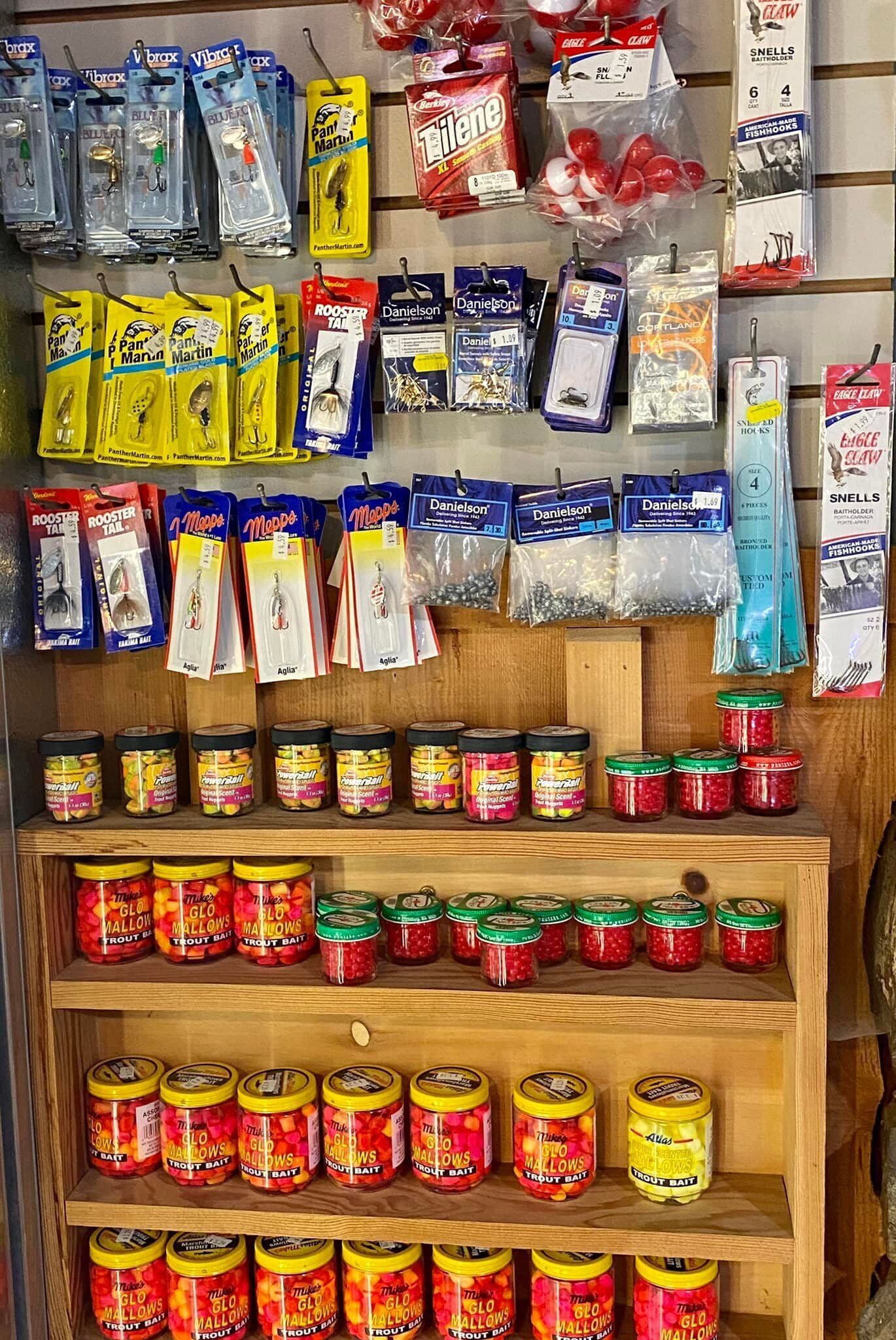 Una tienda de artículos para pesca, con señuelos, cebos y anzuelos exhibidos en estantes y colgados de ganchos.