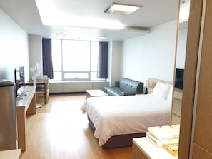 A modern hotel room with a large bed, a desk with a computer, a chair, and a TV. - Goodday Airtel (Incheon)