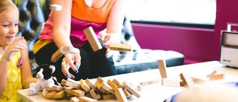 A woman and a child playing with wooden blocks.