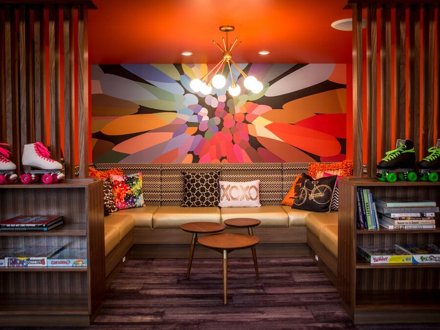 A modern living room with a vibrant mural, a sofa, a coffee table, and roller skates.