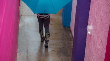 A person walking down a corridor with colorful walls and a wet floor.