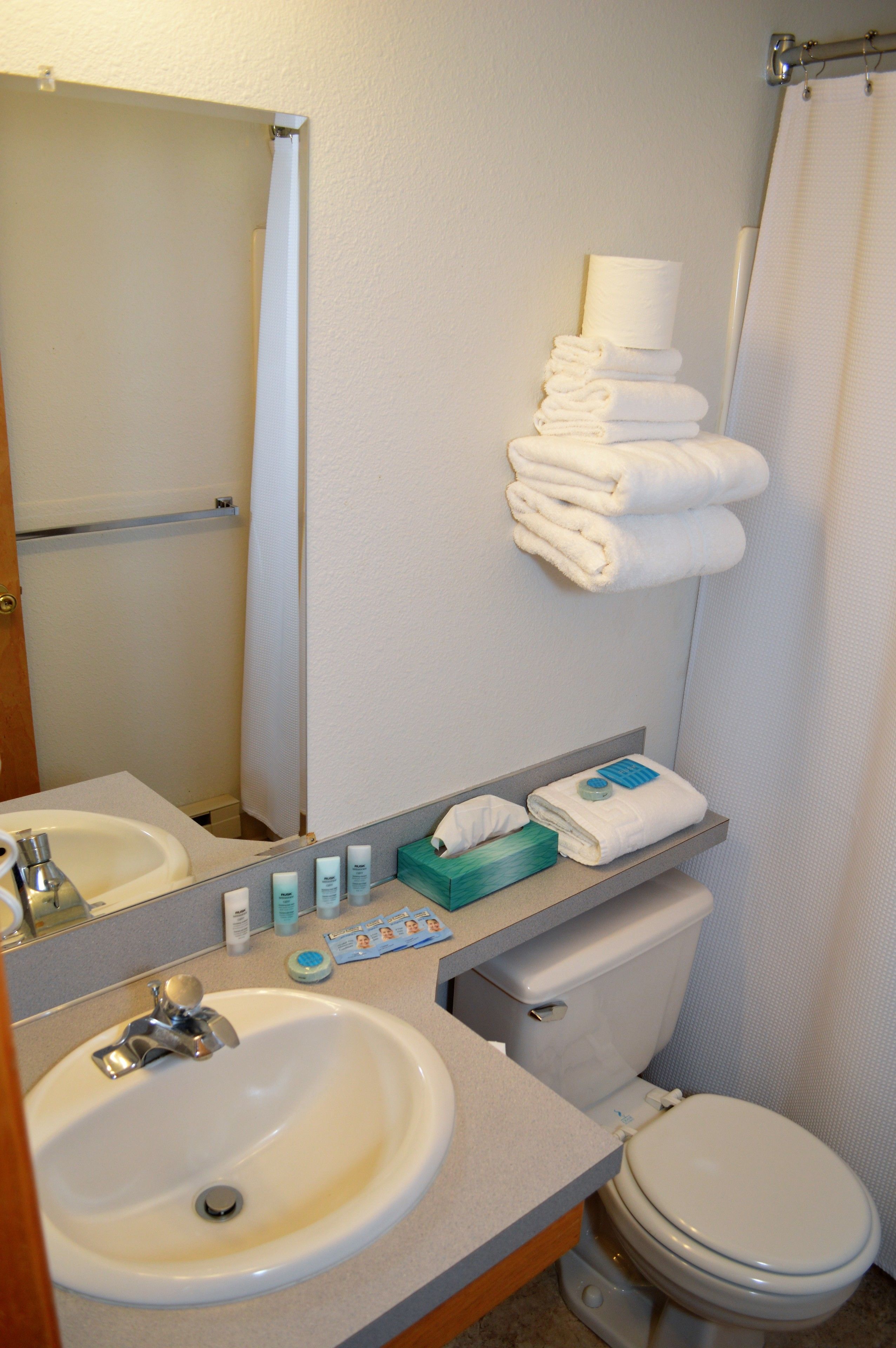 A bathroom with a sink, mirror, towel rack, and toilet.