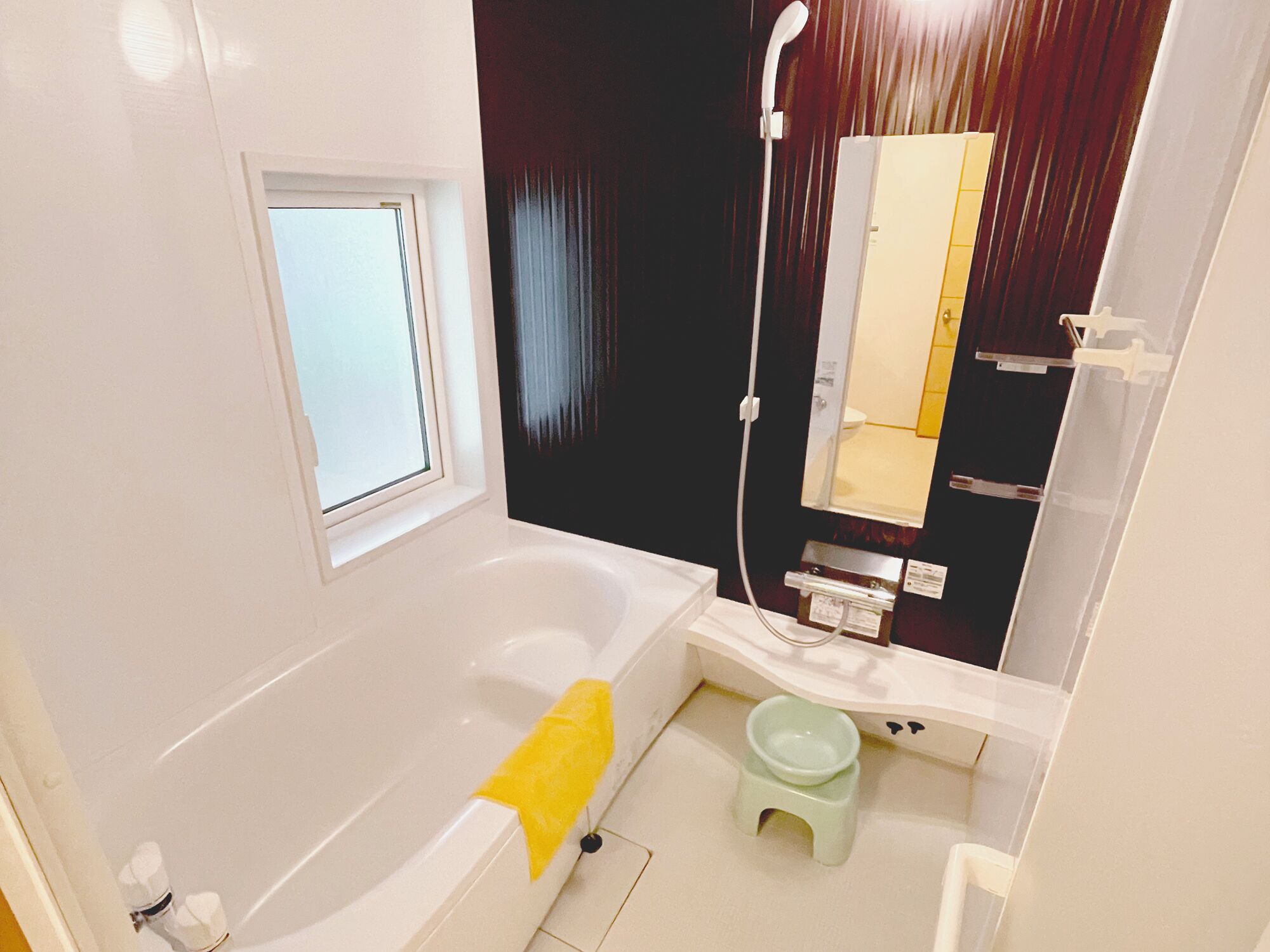 A modern bathroom with a bathtub, a small toilet, and a shower.