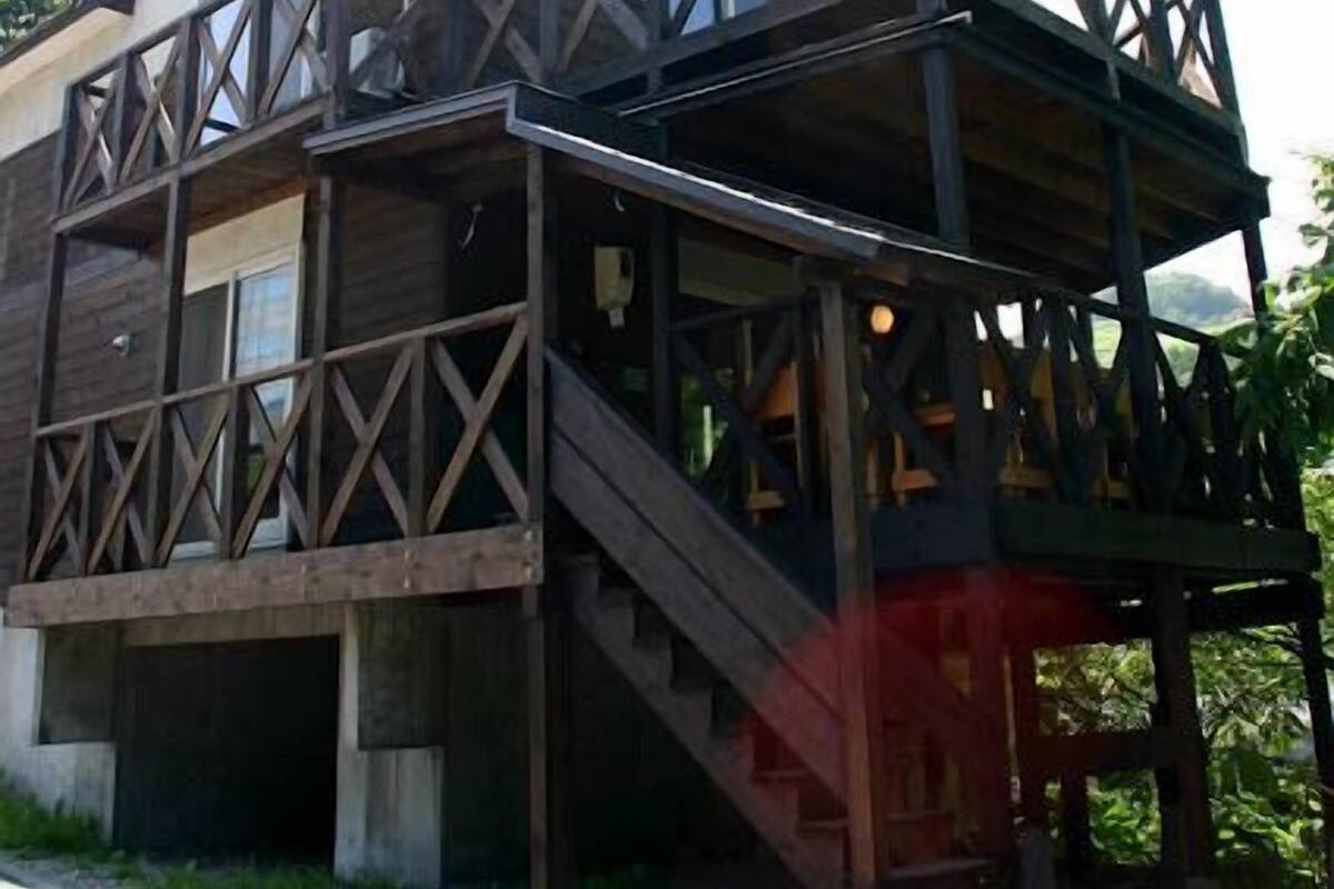 A two-story house with a balcony and a staircase leading to the upper floor.
