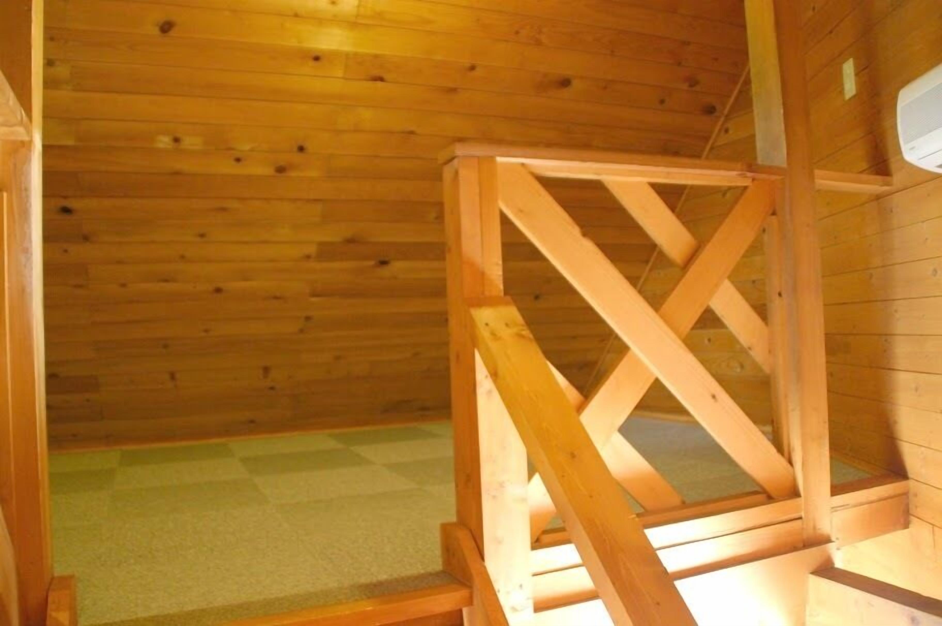 Un intérieur en bois, avec un escalier en bois et un plancher recouvert de moquette.
