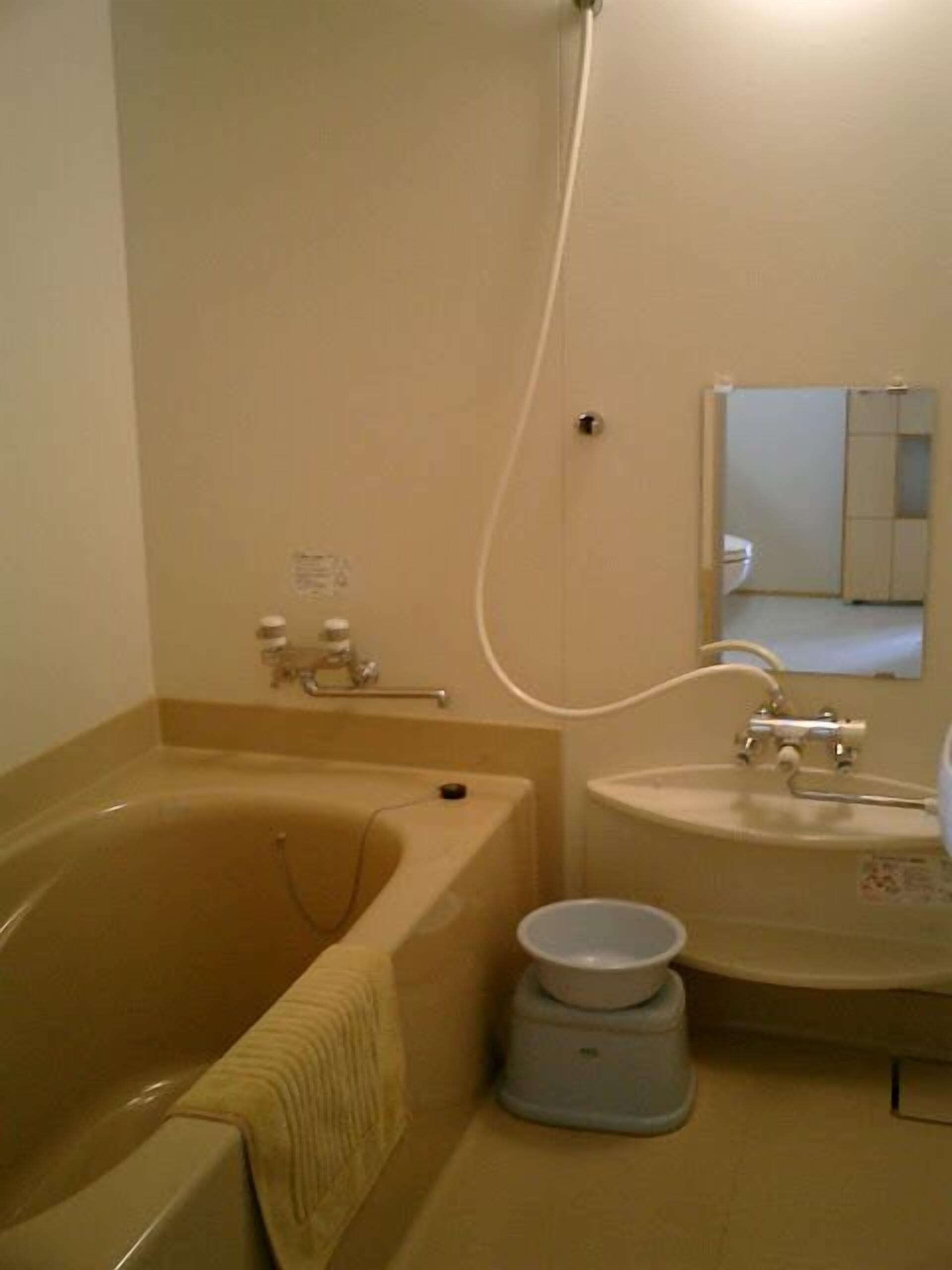 Un baño con bañera, lavamanos y espejo.
