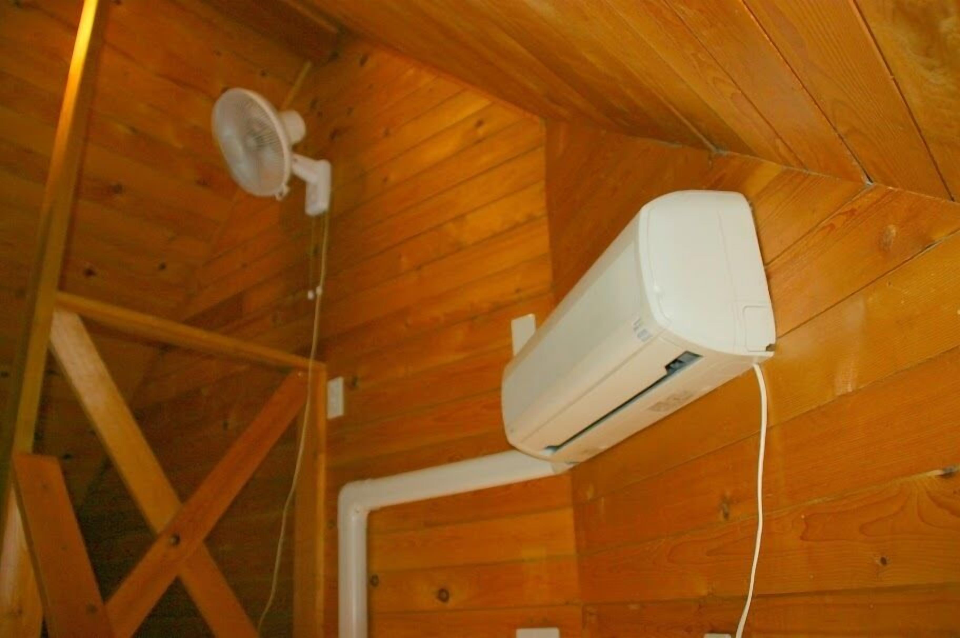 Ein Zimmer mit Holzwänden und einem Deckenventilator.