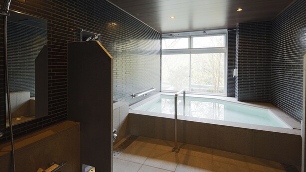 A modern bathroom with a glass-enclosed jacuzzi, a large mirror, and a window providing natural light. - Kyou Bar Lounge & Inn (Sendai)