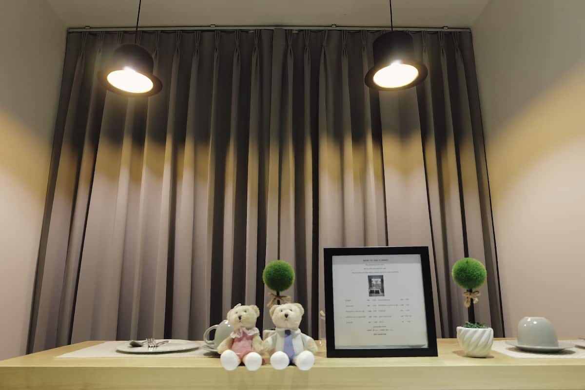 Una mesa de recepción con dos osos de peluche, un documento enmarcado y dos pequeñas macetas.