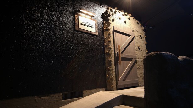 A stone wall with a sign reading "Samurise" and a wooden door. - Hostel&Information SAMURISE (Fujikawaguchiko)