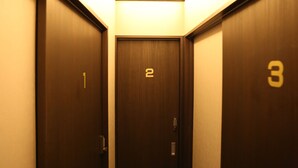A narrow hallway with three doors, each marked with a number. - Hostel&Information SAMURISE (Fujikawaguchiko)