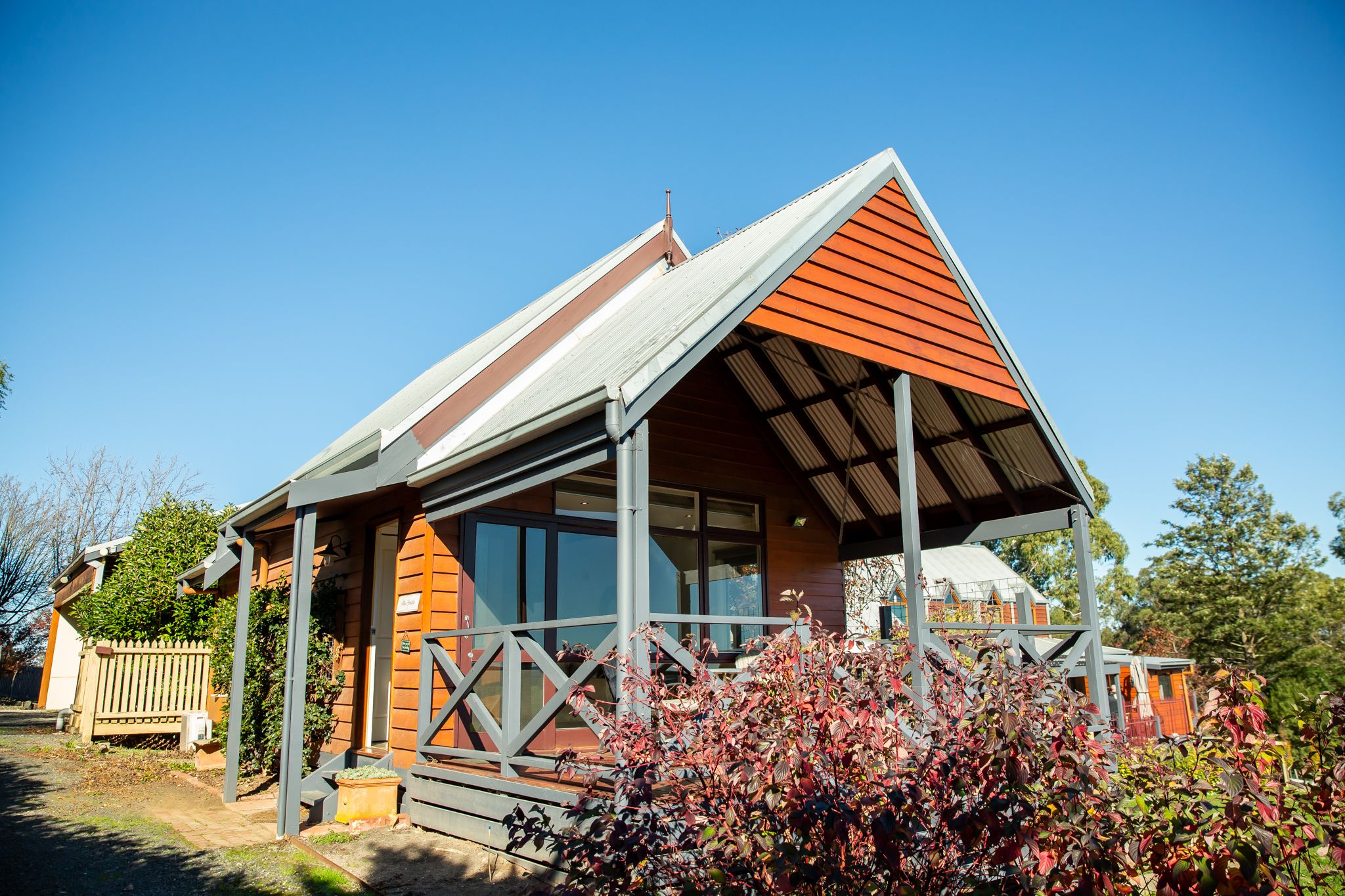 Een modern huis met een schuin dak, grote ramen en een veranda.
