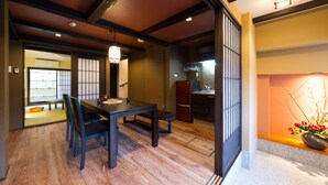 A traditional Japanese room with tatami flooring, a low wooden table, and a sliding door.