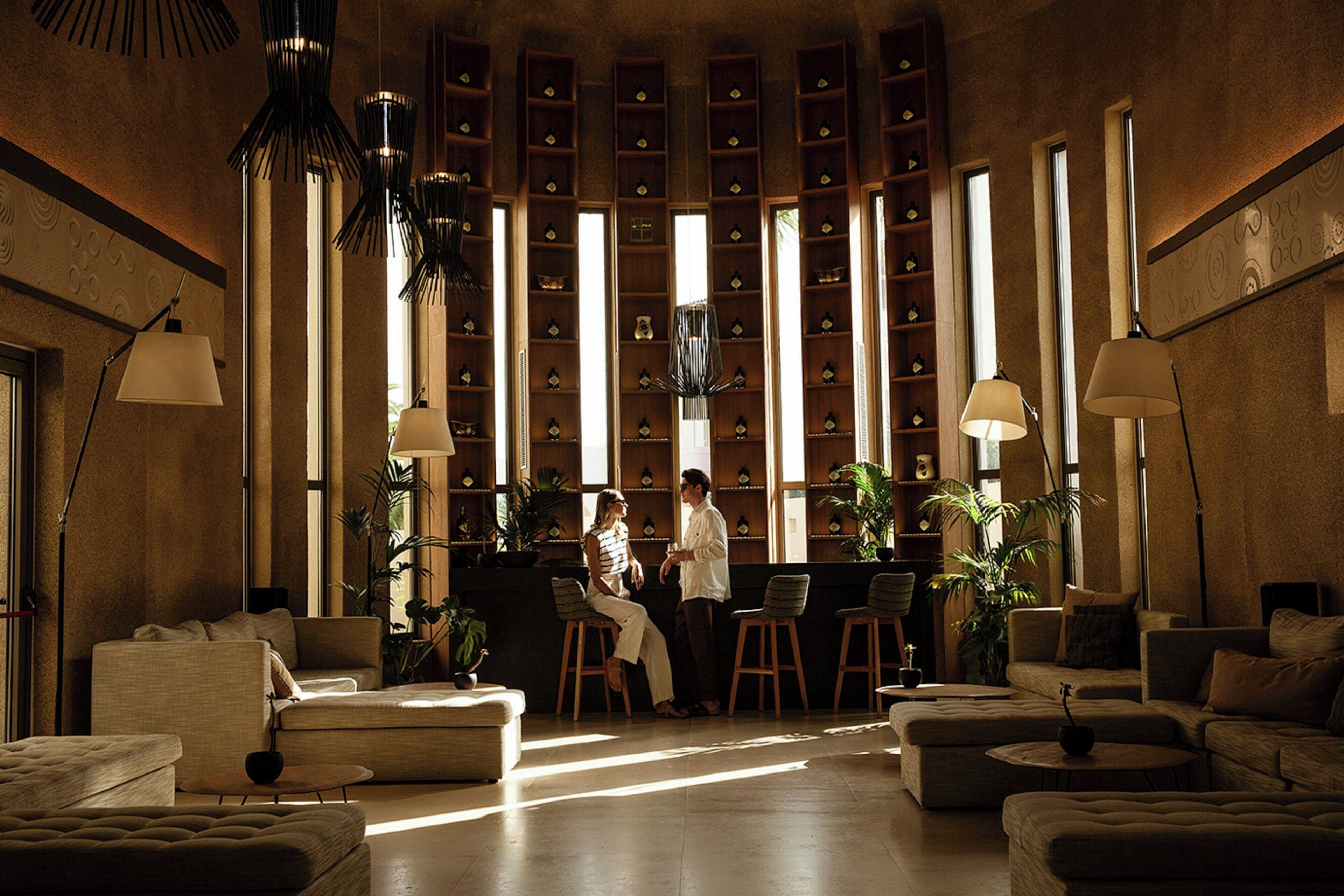 A spacious lobby with a central seating area, multiple bookshelves, and modern lighting fixtures.