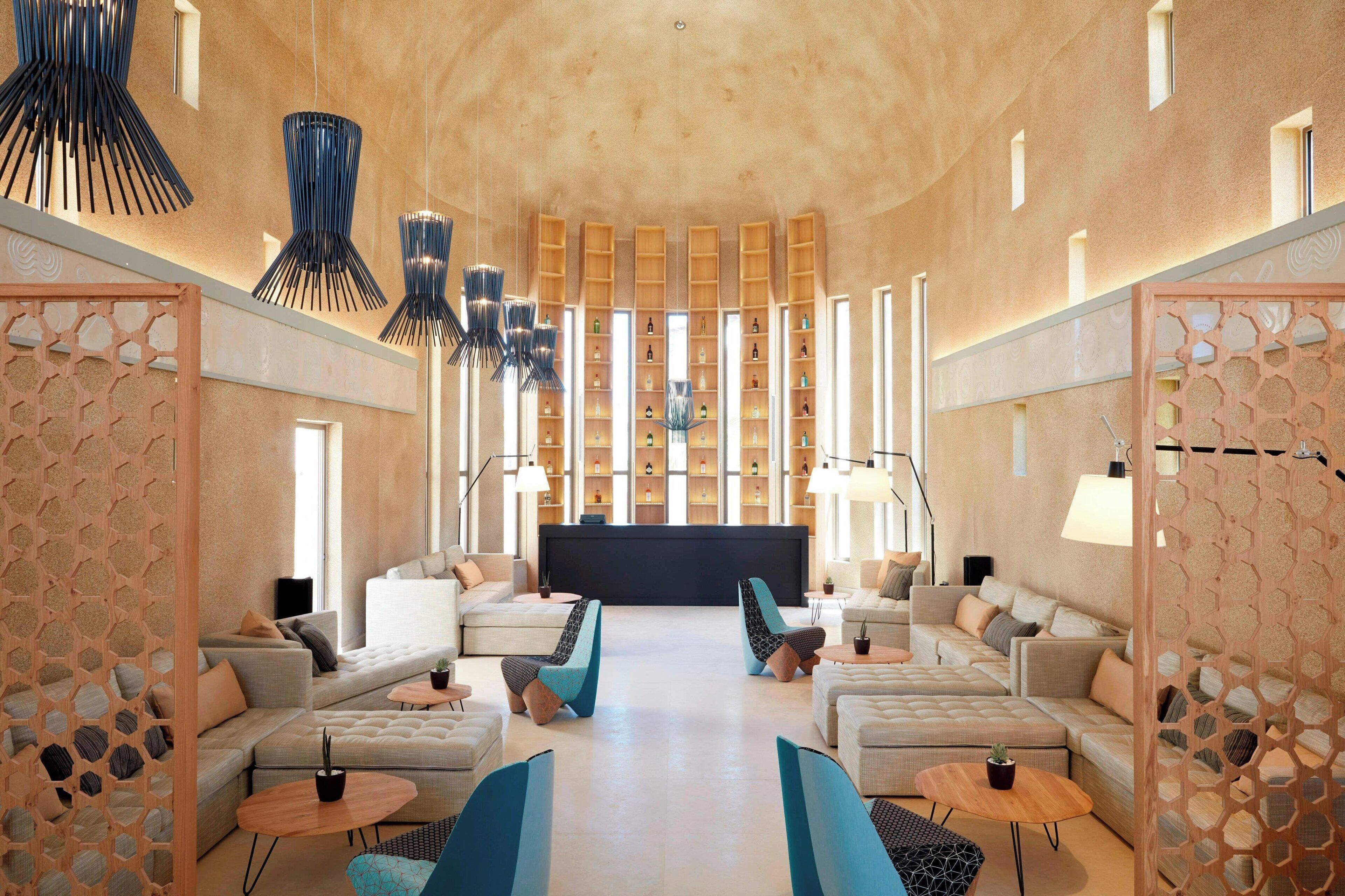 A spacious lobby with sofas, a reception desk, and a large window.
