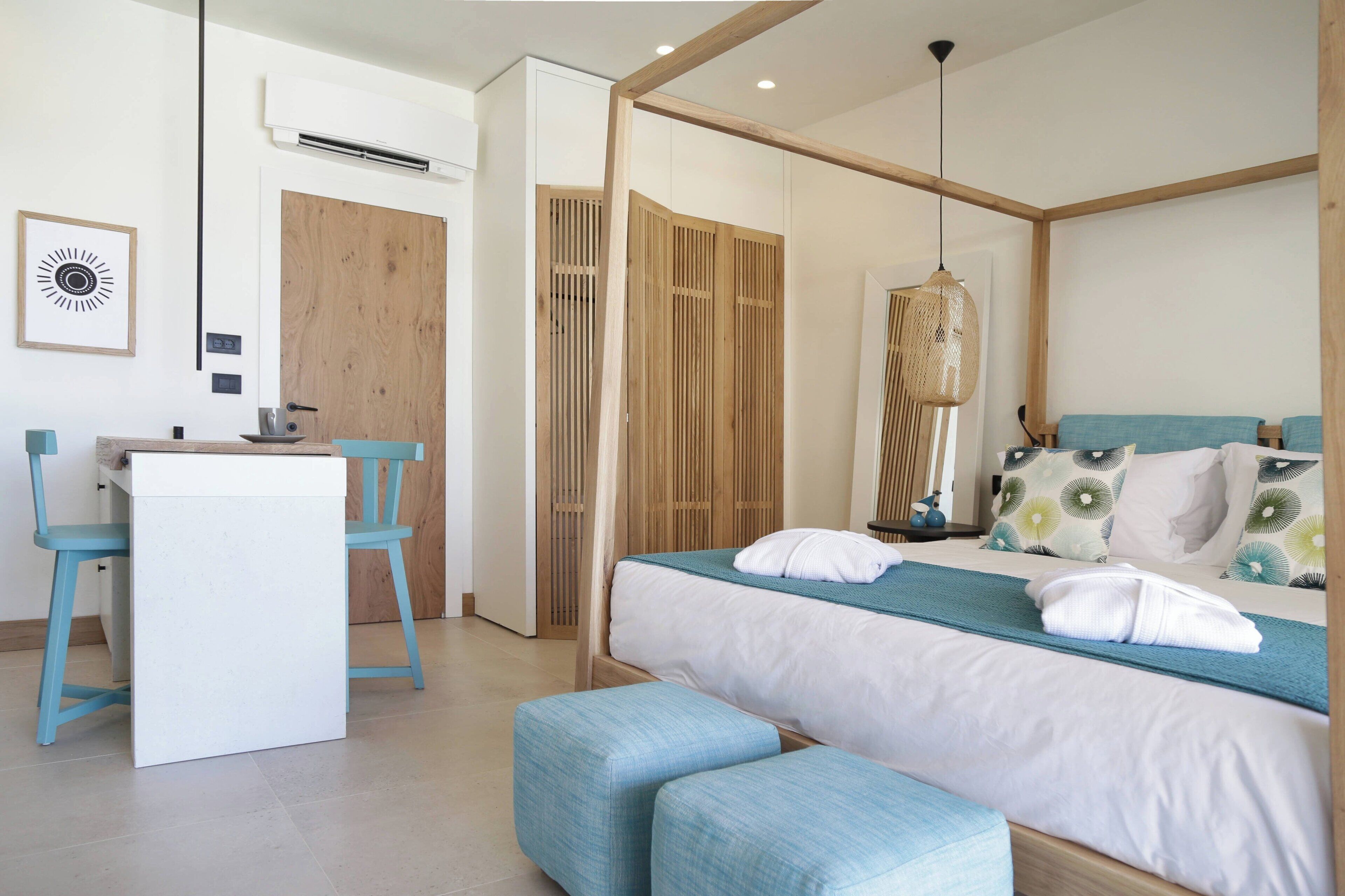 A bedroom with a bed, bedside tables, a desk, and chairs.