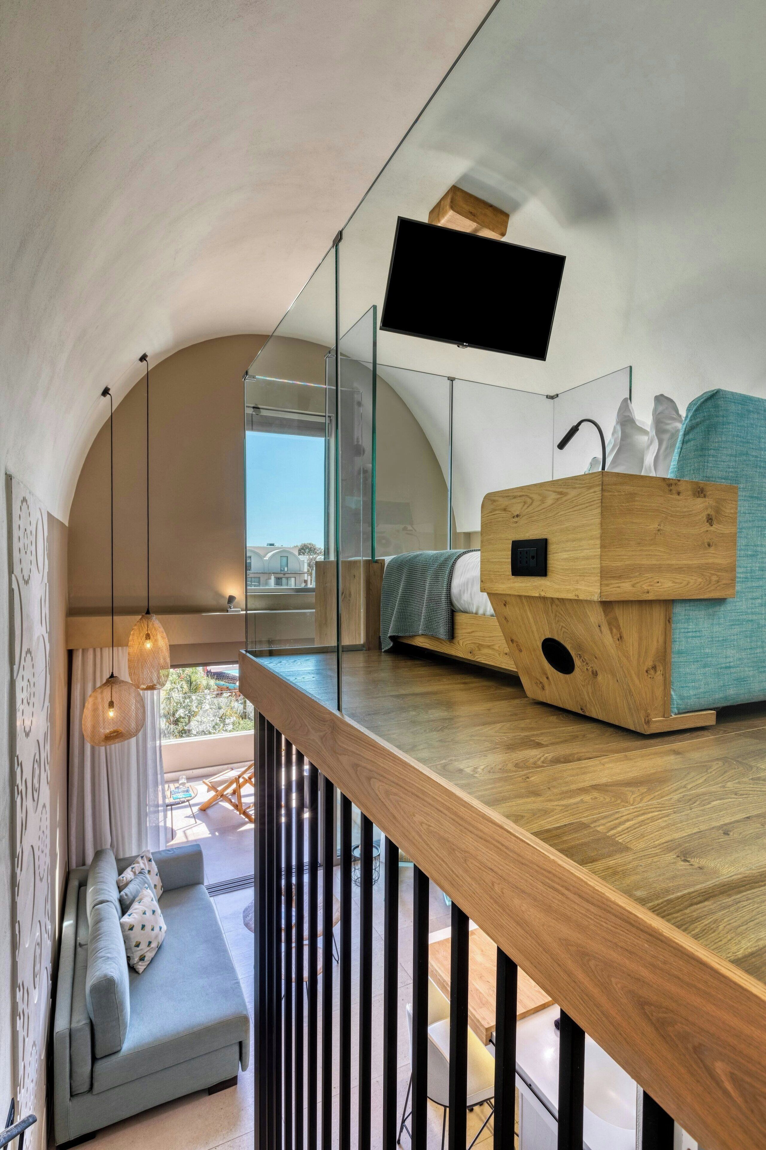 A modern interior with a wooden bench, a sofa, and a flat-screen TV mounted on the wall.