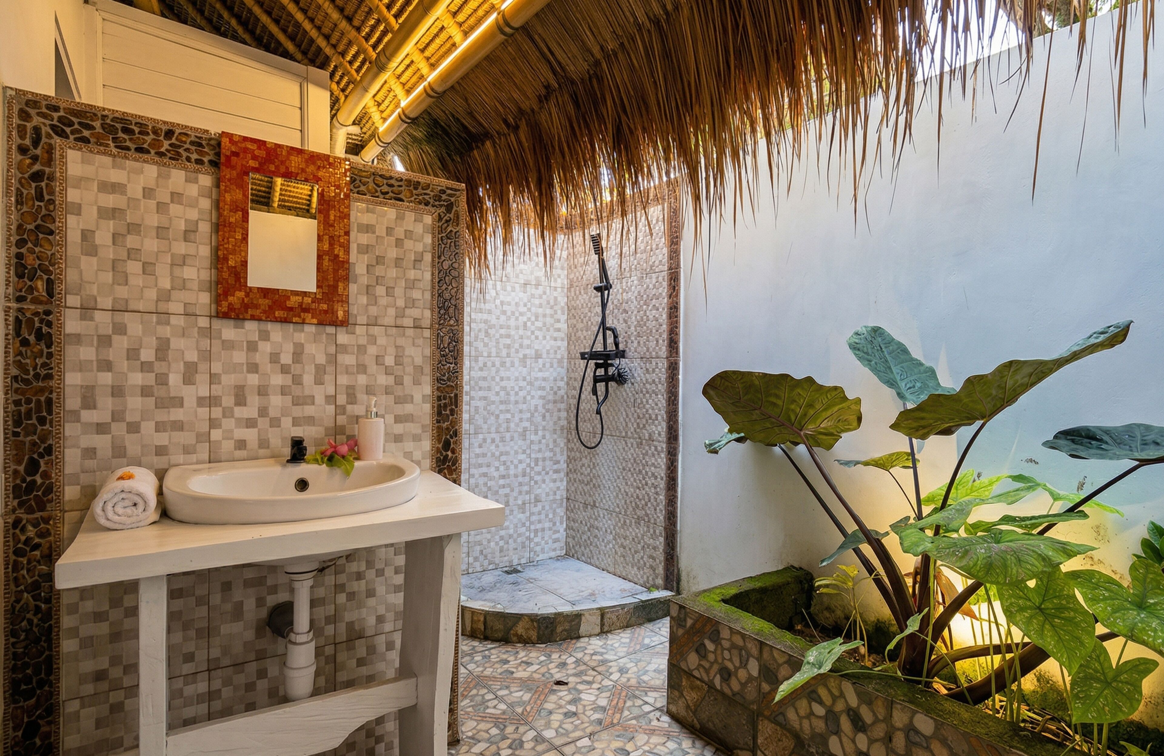 Un baño con lavamanos blanco, un espejo, ducha y suelo de baldosas.