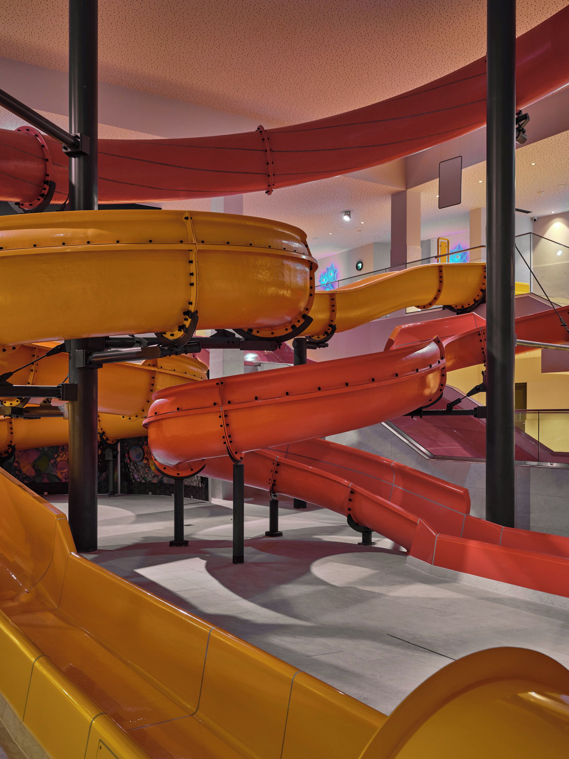 A multi-level indoor slide structure with various colored slides.