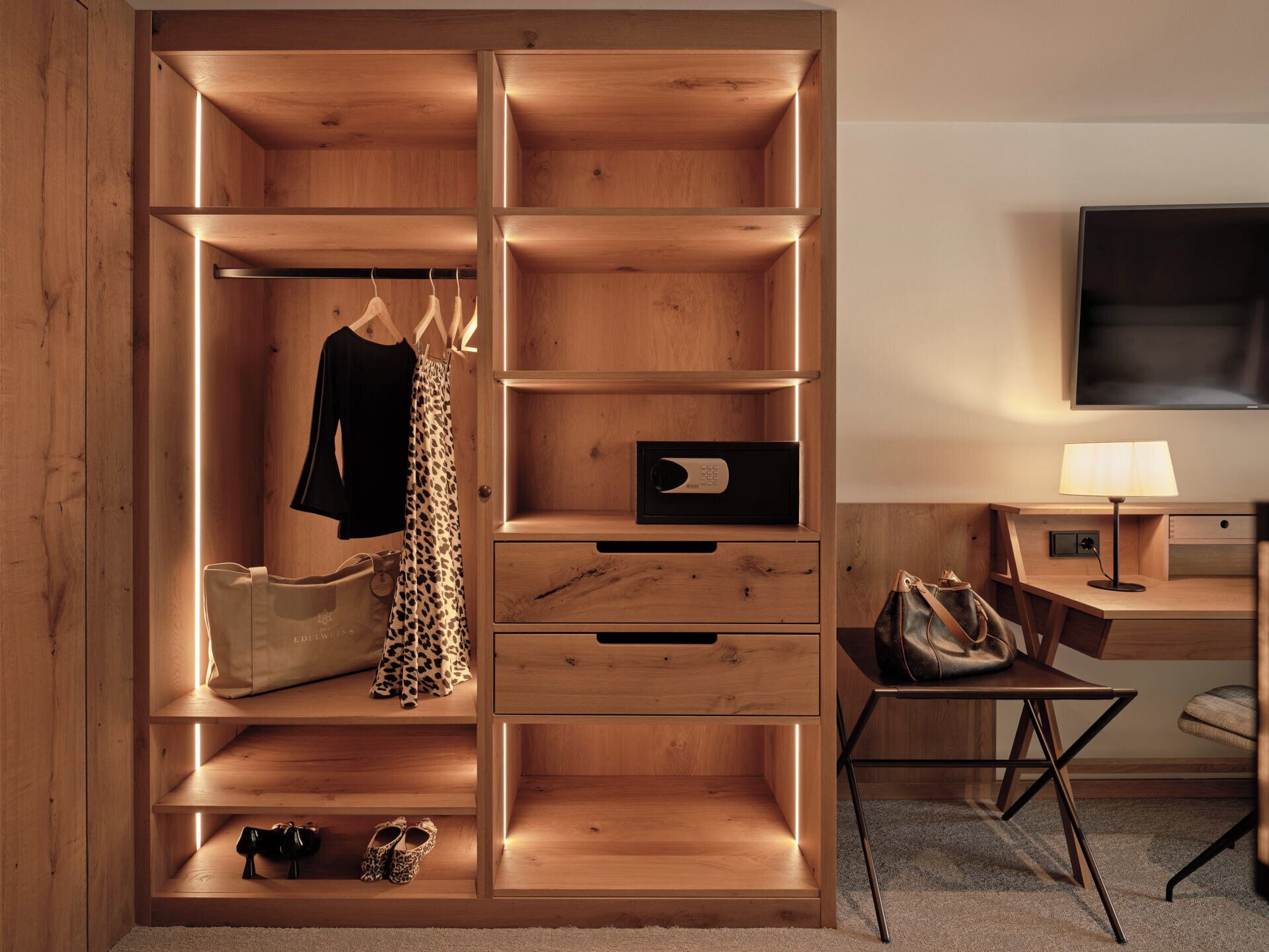 Una habitación moderna con un armario de madera, un escritorio y un televisor.