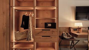 Una habitación moderna con un armario de madera, un escritorio y un televisor.