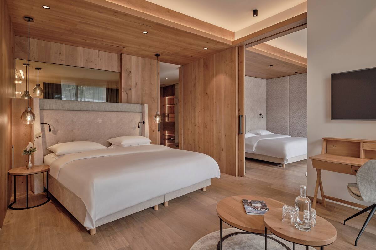 Ein modernes Hotelzimmer mit einem großen Bett, einem Schreibtisch und einem Fernseher.