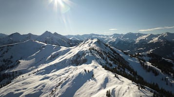 Un paysage montagneux enneigé, avec un ciel dégagé et des montagnes à l’horizon.