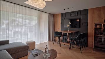 Una sala moderna con sofá, una mesa de centro y un comedor con sillas y una pequeña mesa.