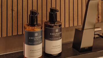 Two bottles of Edelweiss Natur hand soap on a wooden counter.