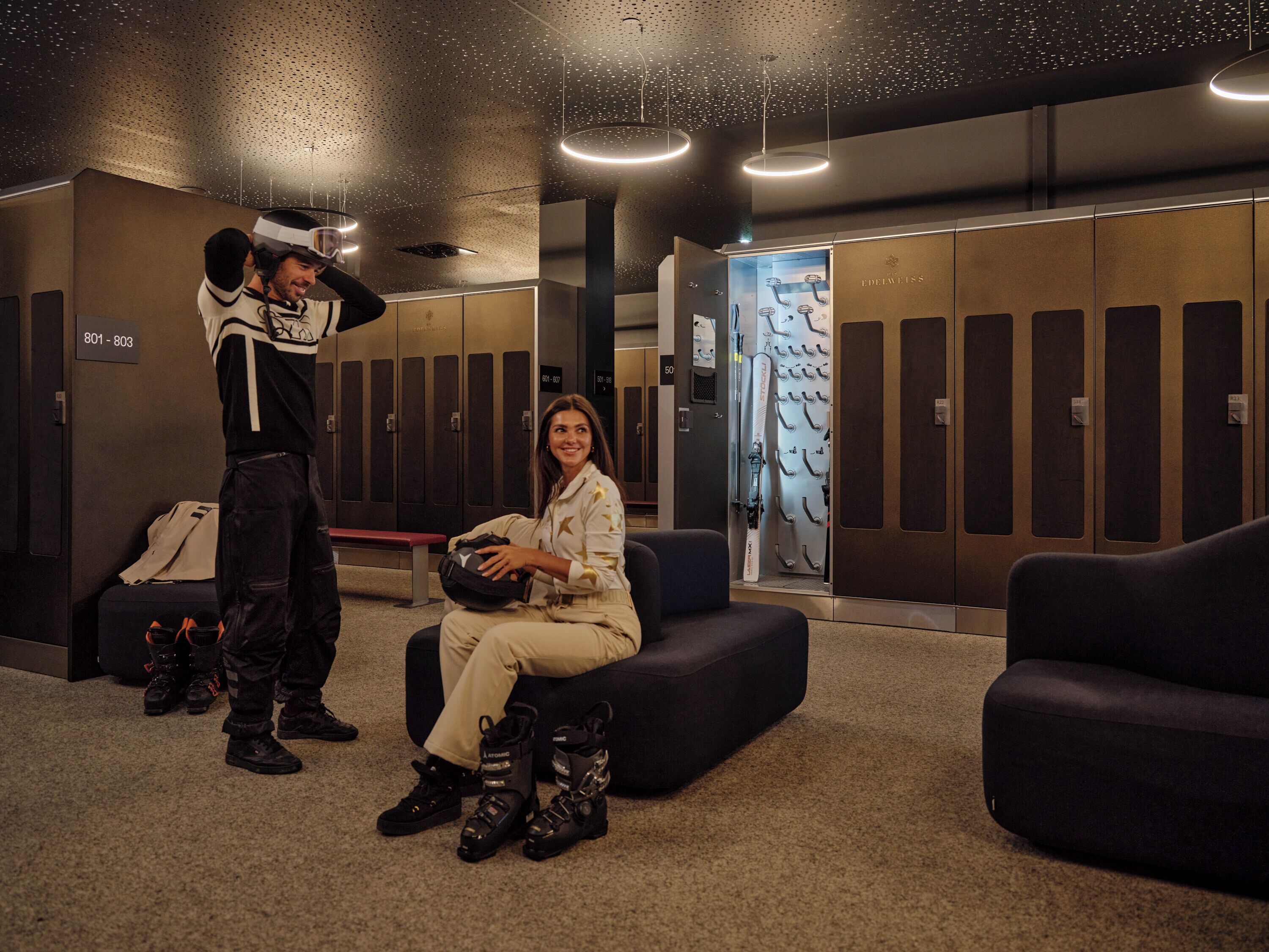 A modern waiting area with lockers, seating, and a bench.