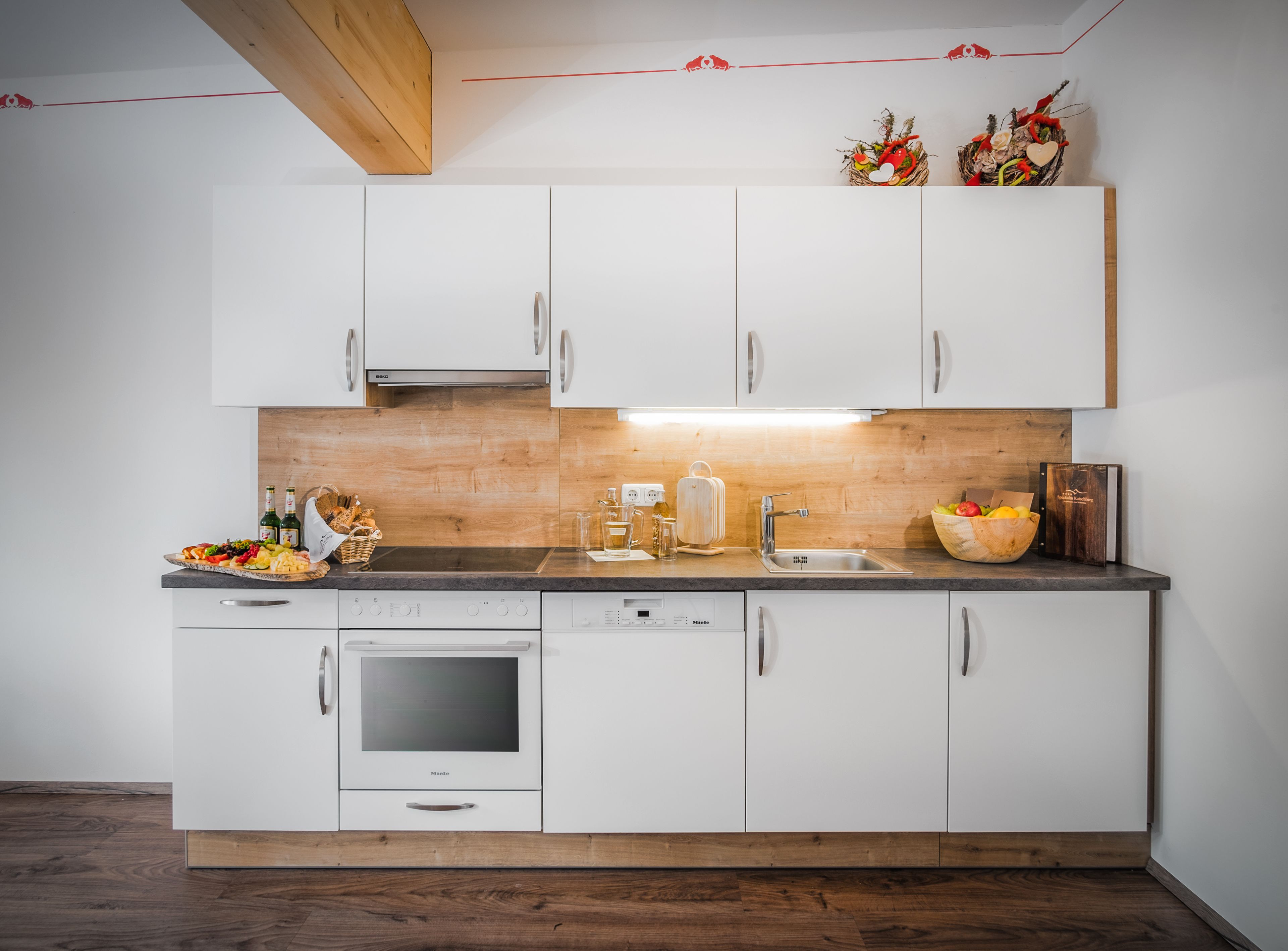 A modern kitchen with white cabinets, a wooden countertop, and a built-in oven.