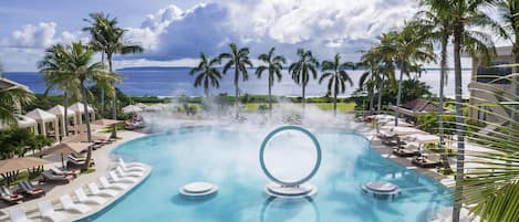 Una piscina al aire libre, camas de piscina con cargo, sombrillas