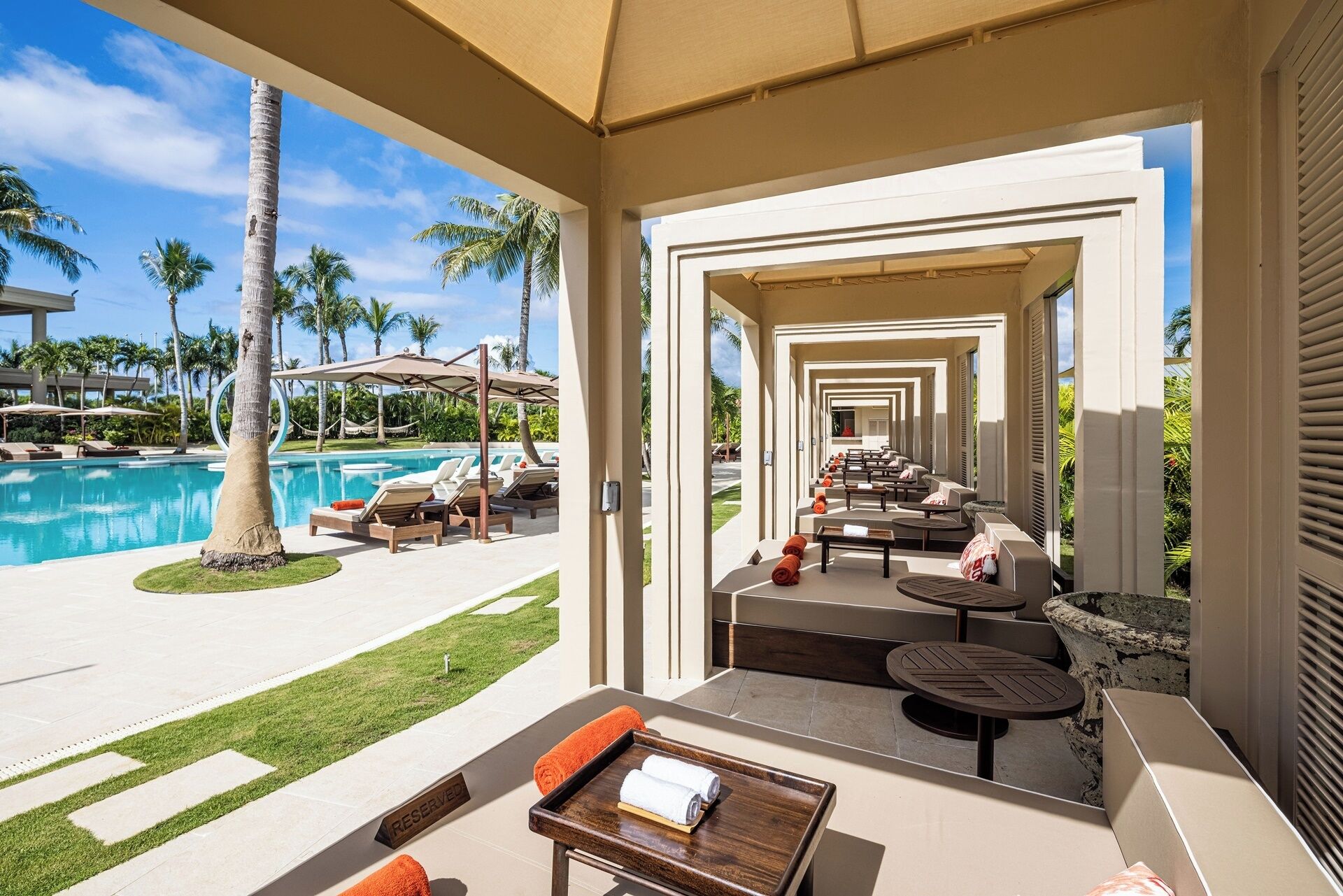 A poolside lounge area with sun loungers, a pool, and a view of the pool.