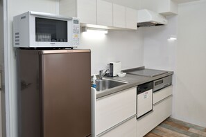 A kitchen with a microwave, refrigerator, sink, and dishwasher.