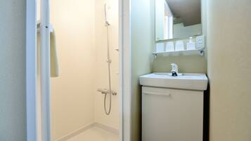 A bathroom with a shower, sink, and mirror.
