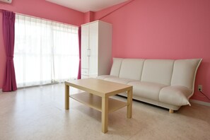 A room with a sofa, a table, a wardrobe, and a window with curtains. - Wallaby House (Kawaguchi)