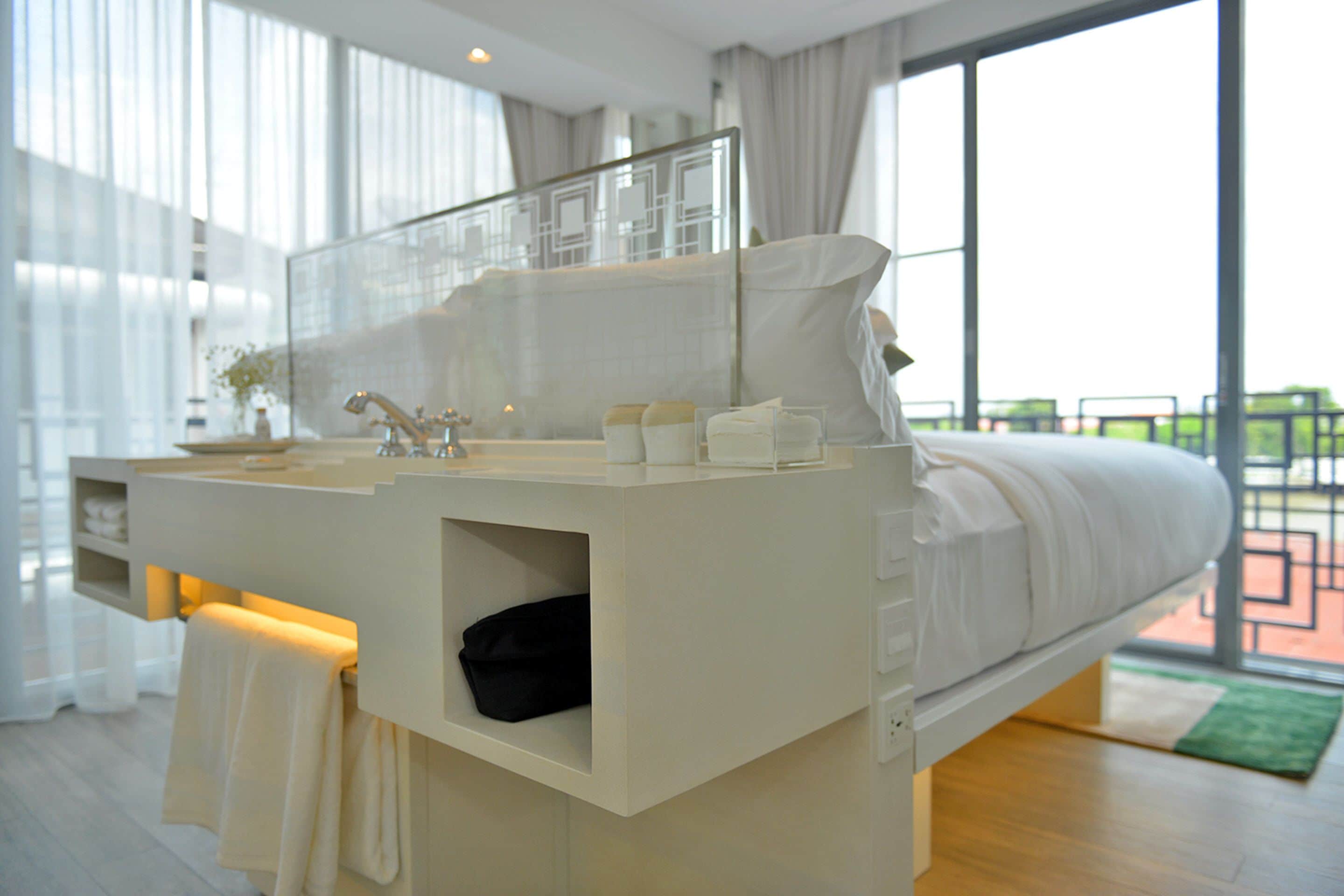 A modern bedroom with a built-in vanity, a large window, and a balcony view.
