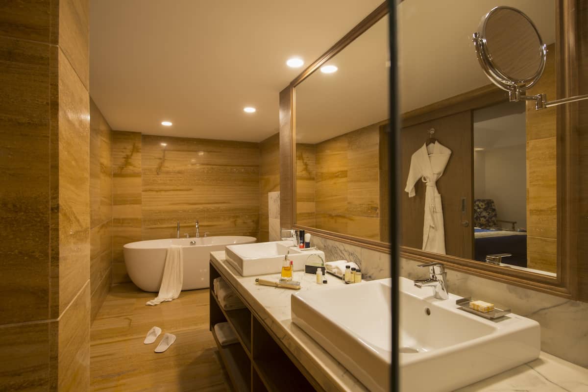 A modern bathroom with a freestanding bathtub, a large mirror, and a vanity with a sink.