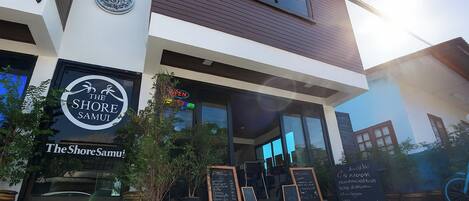 A modern building with a sign reading "The Shore Samui."