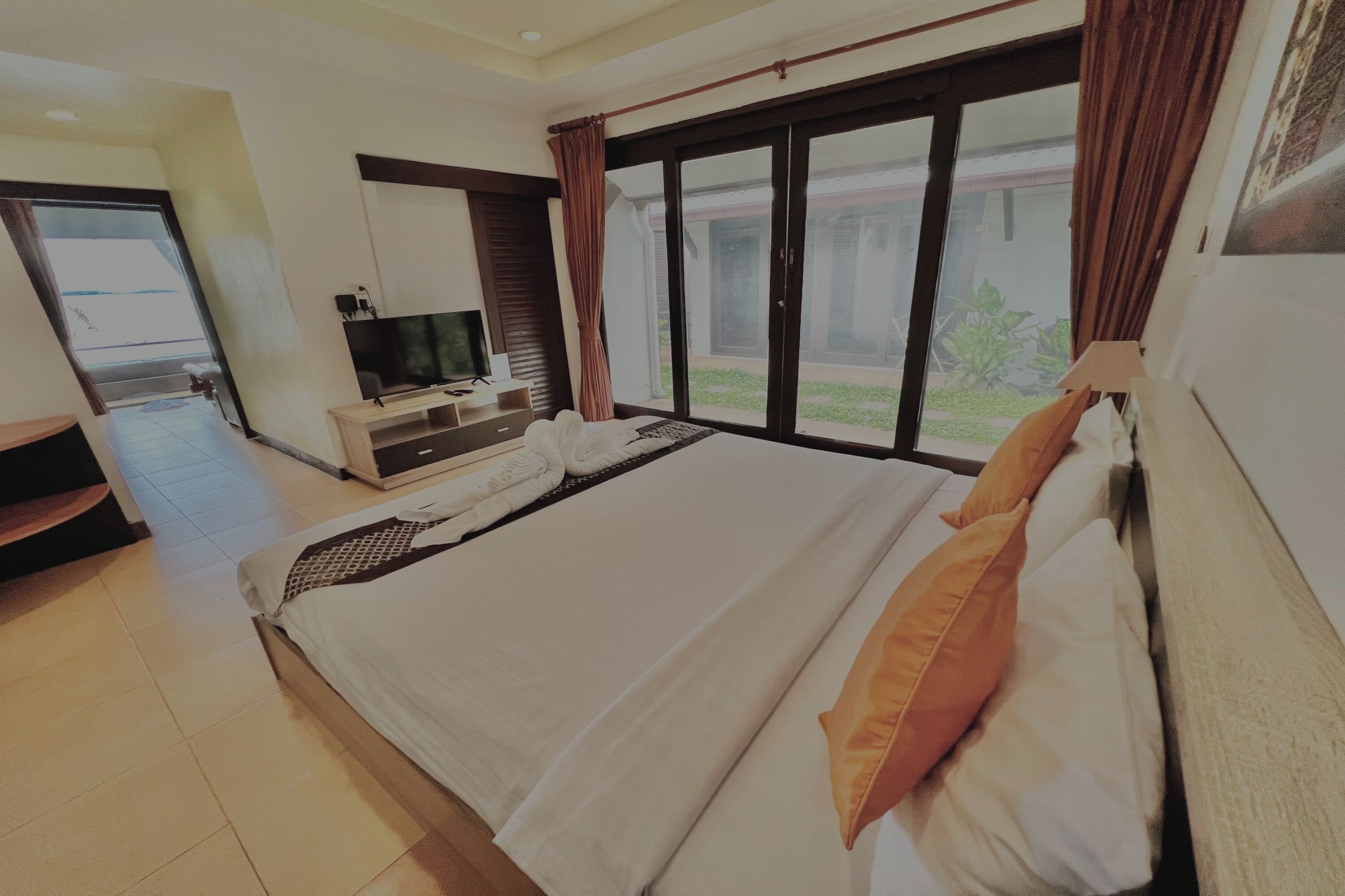 Une chambre d’hôtel avec un grand lit, une télévision, un bureau et une vue sur l’extérieur.