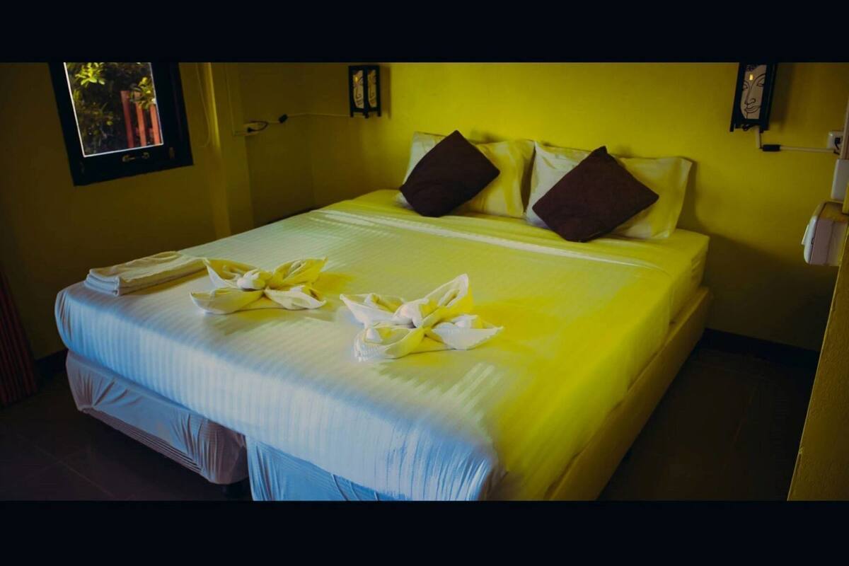 Una habitación de hotel con una cama, almohadas y toallas sobre la misma.