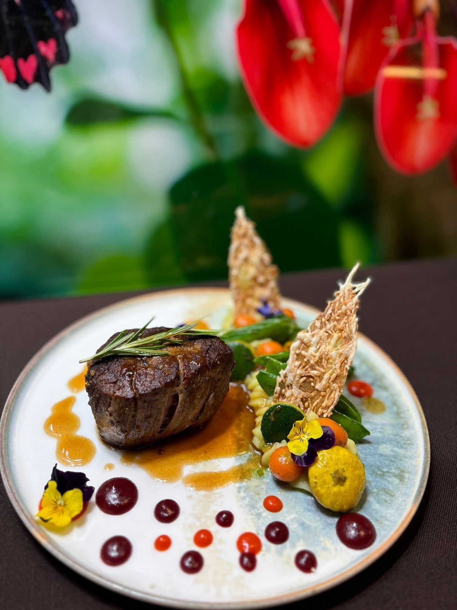 Un plato de comida con un bistec, verduras y adornos.