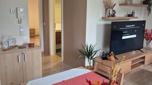 A modern hotel room with a bed, a TV, a desk, and a cabinet. - Hotel Bon Repos (Consdorf)