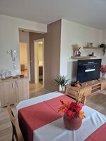 Una habitación de hotel moderna con una cama, televisión, escritorio y armario.